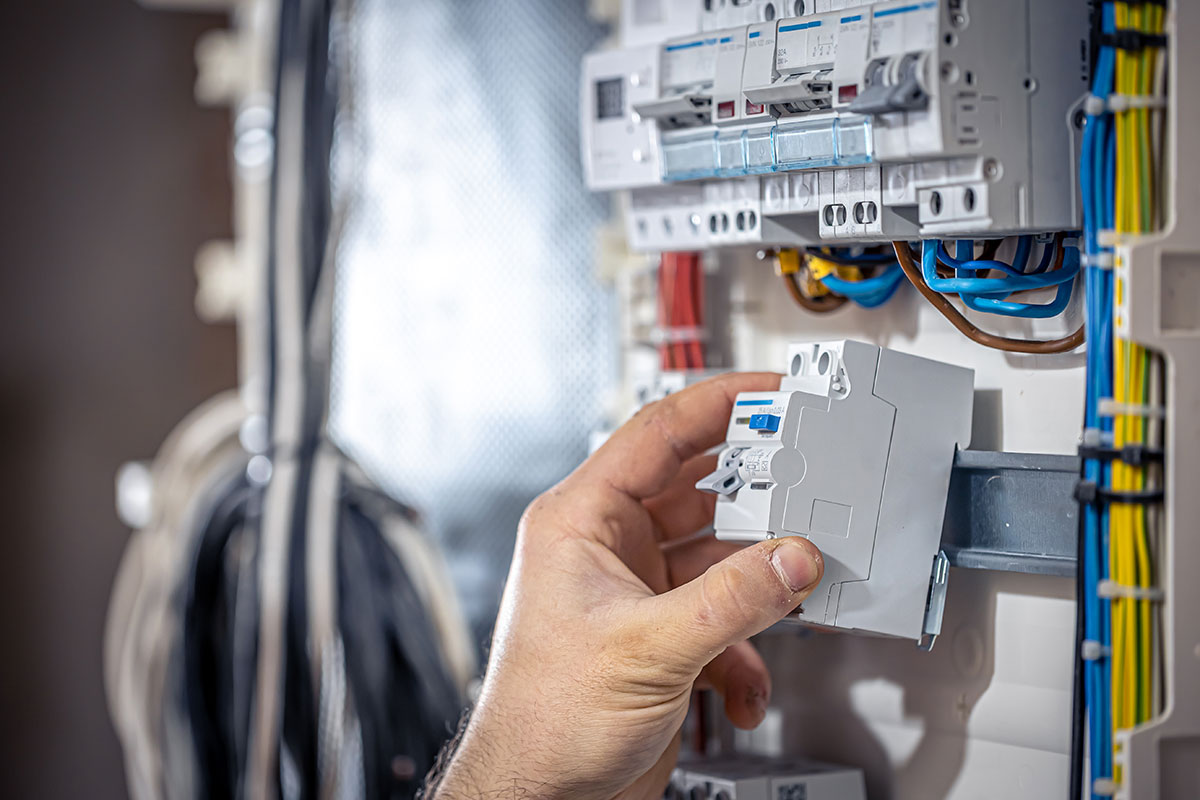 male-electrician-works-switchboard-with-electrical-connecting-cable-(1)
